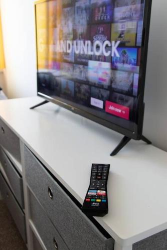 a tv sitting on top of a dresser with a remote control at Station 14 - Vacation Home in Gelligaer