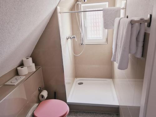 uma casa de banho com um WC cor-de-rosa e um chuveiro em Theox No 13 - 6 Pers - Senseo em Heppenheim
