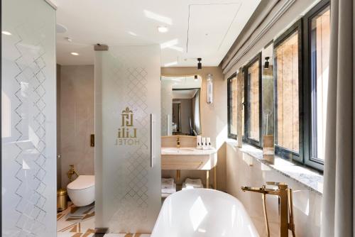 bagno con vasca bianca e lavandino di Bel Mon Resort a Rybnik