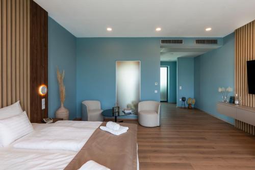 a hotel room with a bed and a blue wall at Zala Springs Golf Resort in Zalacsány