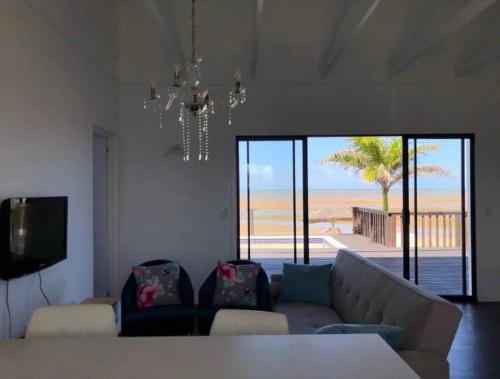 a living room with a couch and a view of the beach at Casa da Praia Catembe in Maputo