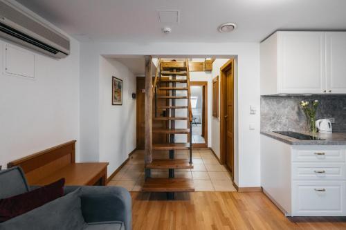a kitchen and living room with a spiral staircase in a room at CATHEDRAL Old Town Suites in Vilnius