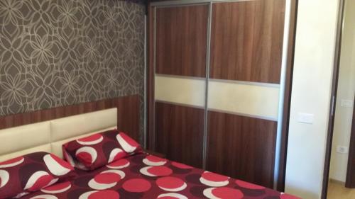 a bedroom with a bed with red and white pillows at Apartment Decebal in Mamaia