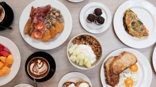 a table topped with plates of breakfast foods at Crowne Plaza Hawkesbury Valley by IHG in Windsor