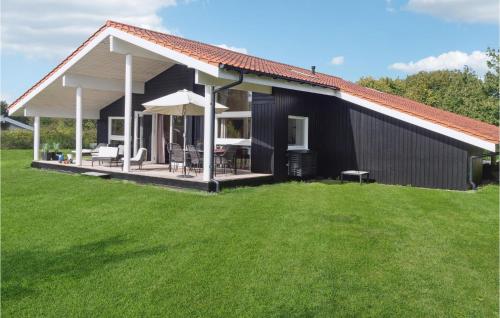 uma casa a preto e branco com um relvado verde em Amazing Home In Askeby With Sauna em Askeby