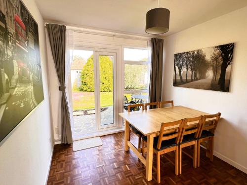 a dining room with a table and chairs and a window at Spacious Family Bungalow with Garden for up to 7 in Epsom