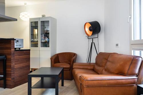 een woonkamer met een bruine leren bank en stoelen bij Eglise catholique - Cosy and bright apartment in Montreux in Montreux