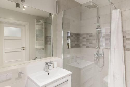 a white bathroom with a sink and a shower at Modern Apartament (10 min walk to Kazimierz) in Krakow