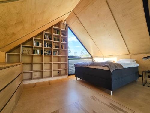 a room with a bed and a book shelf at Dom na Kaszubach Lektura in Fingrowa Huta