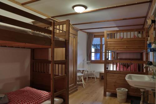 聖安東尼的住宿－Gasthaus Bellawiese，客房设有两张双层床和盥洗盆。