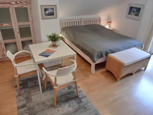 een slaapkamer met een bed en een tafel en stoelen bij Ferienwohnung F6 in Graal-Müritz