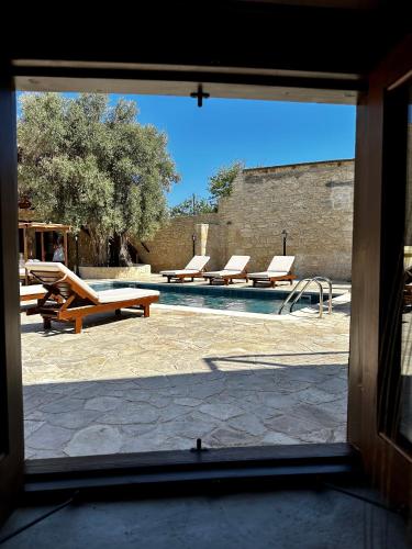 a view of a swimming pool through a window at Stone Court Boutique Studios in Paphos City