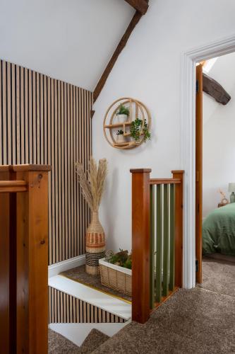 a room with a staircase with a plant in a pot at Stow on the Wold Scandi Chic Authentic Cottage in Stow on the Wold
