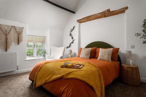 a bedroom with a large bed with an orange blanket at Stow Newly Remodeled Scandi Chic in Stow on the Wold