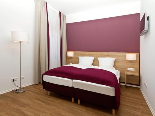 a bedroom with a large bed with a purple wall at Landgasthaus zur Linde in Pleiskirchen