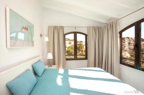 1 dormitorio con 1 cama azul y 2 ventanas en VH CostaBlanca - ALOSA, en Benissa
