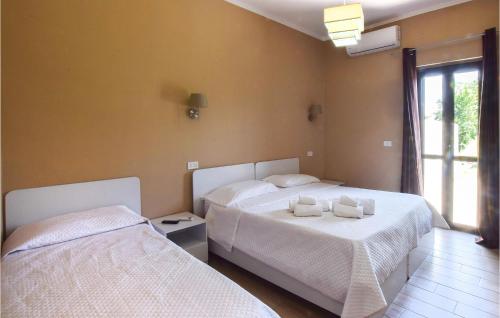 um quarto com 2 camas e uma janela em 1 Bedroom Cozy Apartment In Gizzeria em Gizzeria