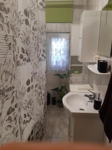a bathroom with a sink and a shower curtain at Domek u Prezesa 