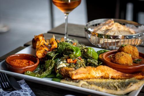 a plate of food on a table with a glass of wine at art Hotel Tucholsky in Bochum