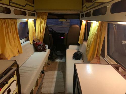 a van with white seats and yellow curtains at Autocaravana Sally in Lisbon