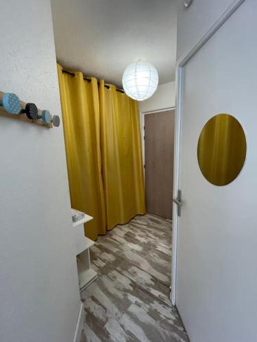 un couloir avec une porte et un rideau jaune dans l'établissement Brest Saint-Marc : appart T1 bis bien situé wifi, à Brest