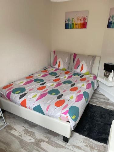 une chambre avec un lit avec une couette colorée dans l'établissement Brest Saint-Marc : appart T1 bis bien situé wifi, à Brest