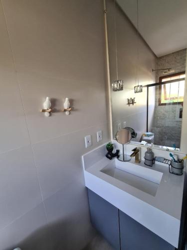 a white bathroom with a sink and a mirror at Refúgio dos Coiotes in Cambara do Sul