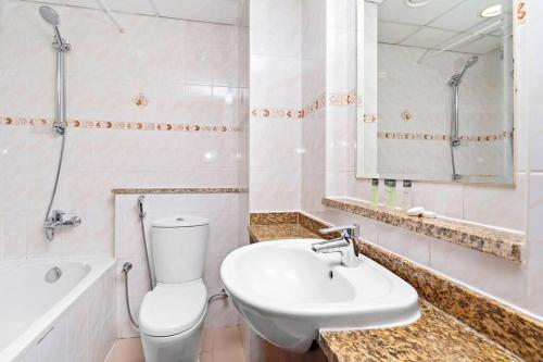 La salle de bains blanche est pourvue d'un lavabo et de toilettes. dans l'établissement StoneTree - Studio with Amazing View in JLT, à Dubaï