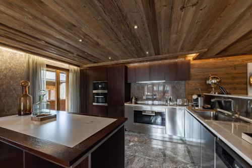 a large kitchen with wooden ceilings and a counter top at Ultima Gstaad Residences in Gstaad