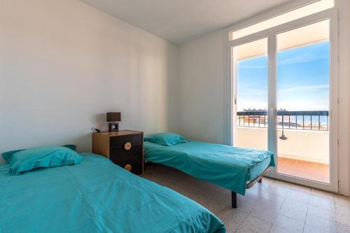 une chambre avec deux lits et une grande fenêtre dans l'établissement Bel Orizonte, Grand appart 70m2 vue mer, à Ajaccio