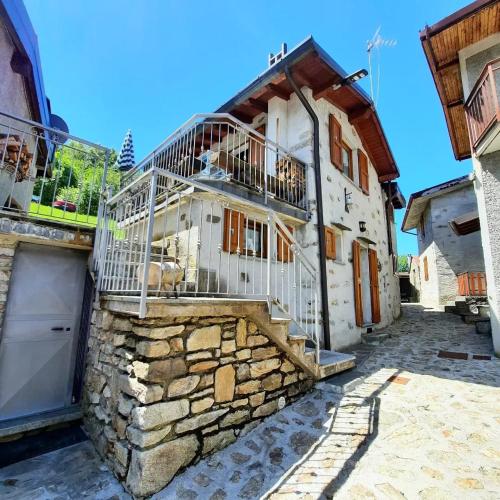 una casa in pietra con balcone sul lato di Baita Margherita a Casargo