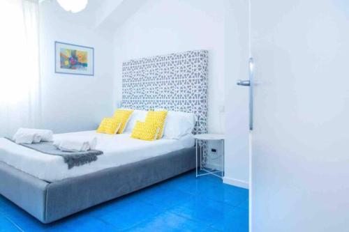 トラッペートにある4 bedrooms apartement at Piano di Trappeto 10 m away from the beach with sea view furnished terrace and wifiの白いベッドルーム(黄色い枕のベッド付)