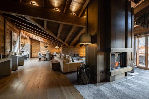 a living room with wooden ceilings and a fireplace at Ultima Gstaad Residences in Gstaad