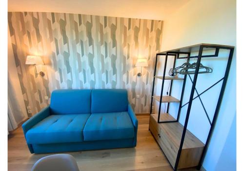 un divano blu in un soggiorno accanto a uno scaffale di AU 237'- Résidence Aquatis - Futuroscope - La Conciergerie. a Chasseneuil-du-Poitou