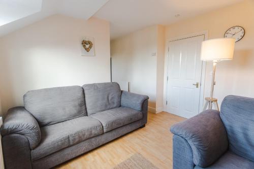 een woonkamer met een bank en een stoel bij May Disc - Long Stay - Contractors in Swindon