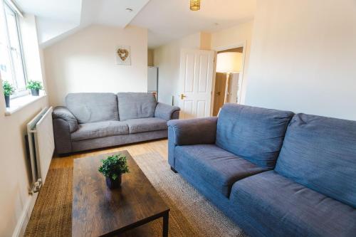 a living room with a blue couch and a table at June Disc - Long Stay - Contractors in Swindon