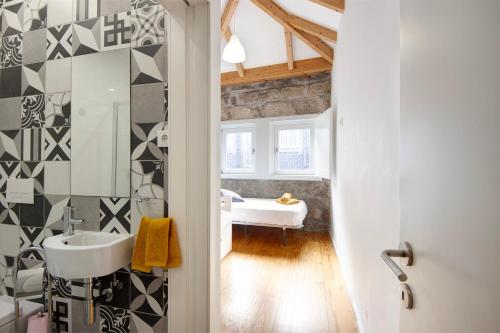 W łazience znajduje się umywalka i lustro. w obiekcie Lidador House Vila do Conde w mieście Vila do Conde