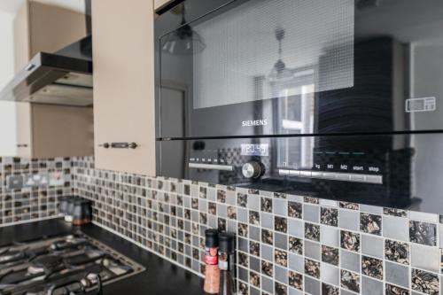 a kitchen with a tile counter top with a stove at Charming 1 Bed Flat w Courtyard in Central London in London