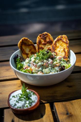 a bowl of salad with toast and dip on a wooden table at art Hotel Tucholsky in Bochum