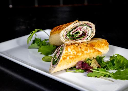 a sandwich on a white plate with a salad at art Hotel Tucholsky in Bochum