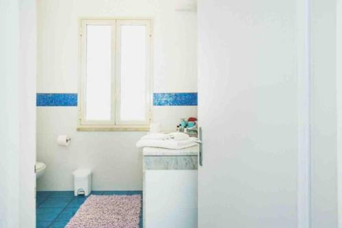 een badkamer met een wastafel en een raam bij 3 bedrooms apartement at Piano di Trappeto 1 m away from the beach with sea view furnished terrace and wifi in Trappeto