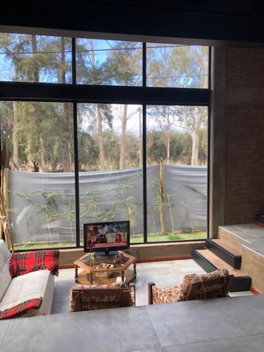 a living room with a large window and a television at Entrepinos in Mendoza
