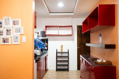 a kitchen with red cabinets and a staircase in it at The Greens Home & Garden - ENTIRE 3RD FLOOR in Baguio