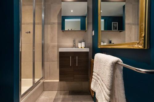 ein Bad mit einer Dusche, einem Waschbecken und einem Spiegel in der Unterkunft Modern apartment with the best Mont Blanc view! in Chamonix-Mont-Blanc