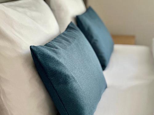 two blue pillows sitting on top of a bed at Hotel Schöne Aussicht in Wilhelmshaven