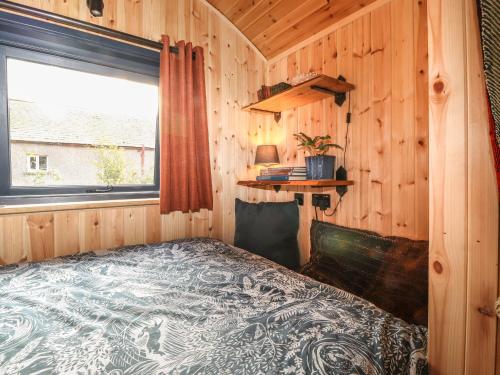 a bedroom with a bed in a wooden cabin at Dunfell Shepherd's Hut in Dufton