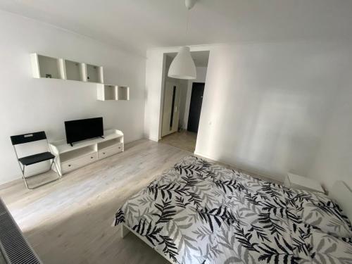 a white bedroom with a bed and a television at Relax Studio Militari Residence Sector 6 in Roşu