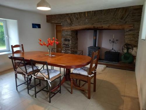 una sala da pranzo con tavolo, sedie e camino di Babeann's at Kilmeen Wood Farm, West Cork a Clonakilty