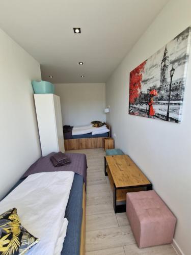 Zimmer mit 2 Betten und einem Tisch in der Unterkunft YourSecondFlat Sobieski Apartment in Dębica