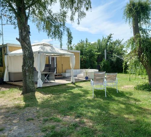 um quintal com duas cadeiras e um guarda-sol branco em Lyckans Lodge em Dösjebro